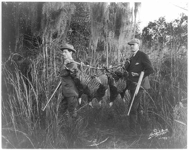 Vintage black and white photo of hunters with wild game